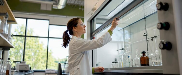 Researcher adjusting lab fume hood sash